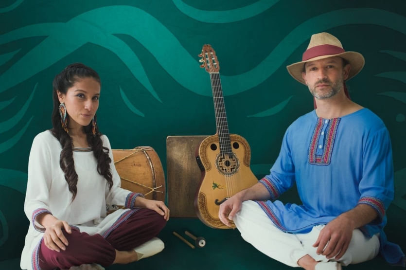 Fotografía de la pareja de Danza colibrí con instrumentos al fondo