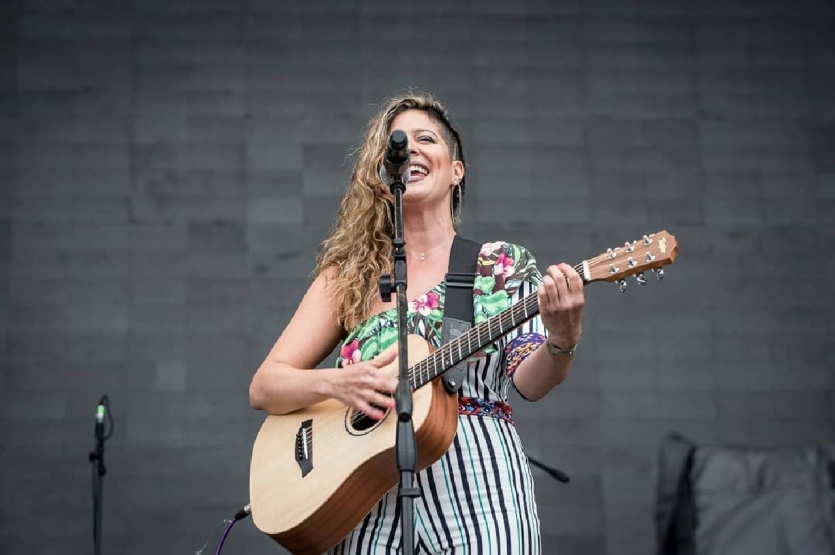 Fotografía de María Vanedi en escena tocando guitarra